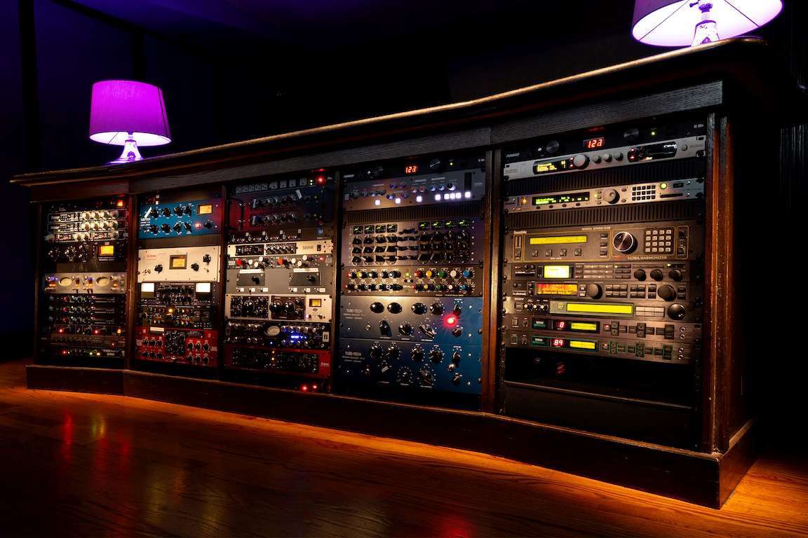 A rack of electronic equipment in a dark room.